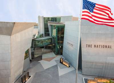 Roof-height view of the exterior of the National WWII Museum with American flag featured