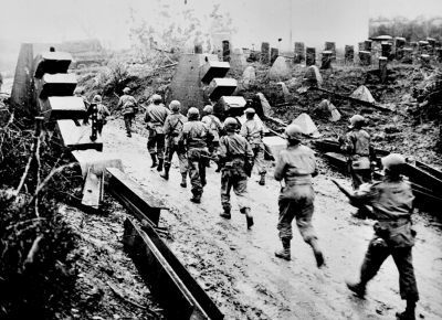 US troops marching through the remains of the Siegfried Line.