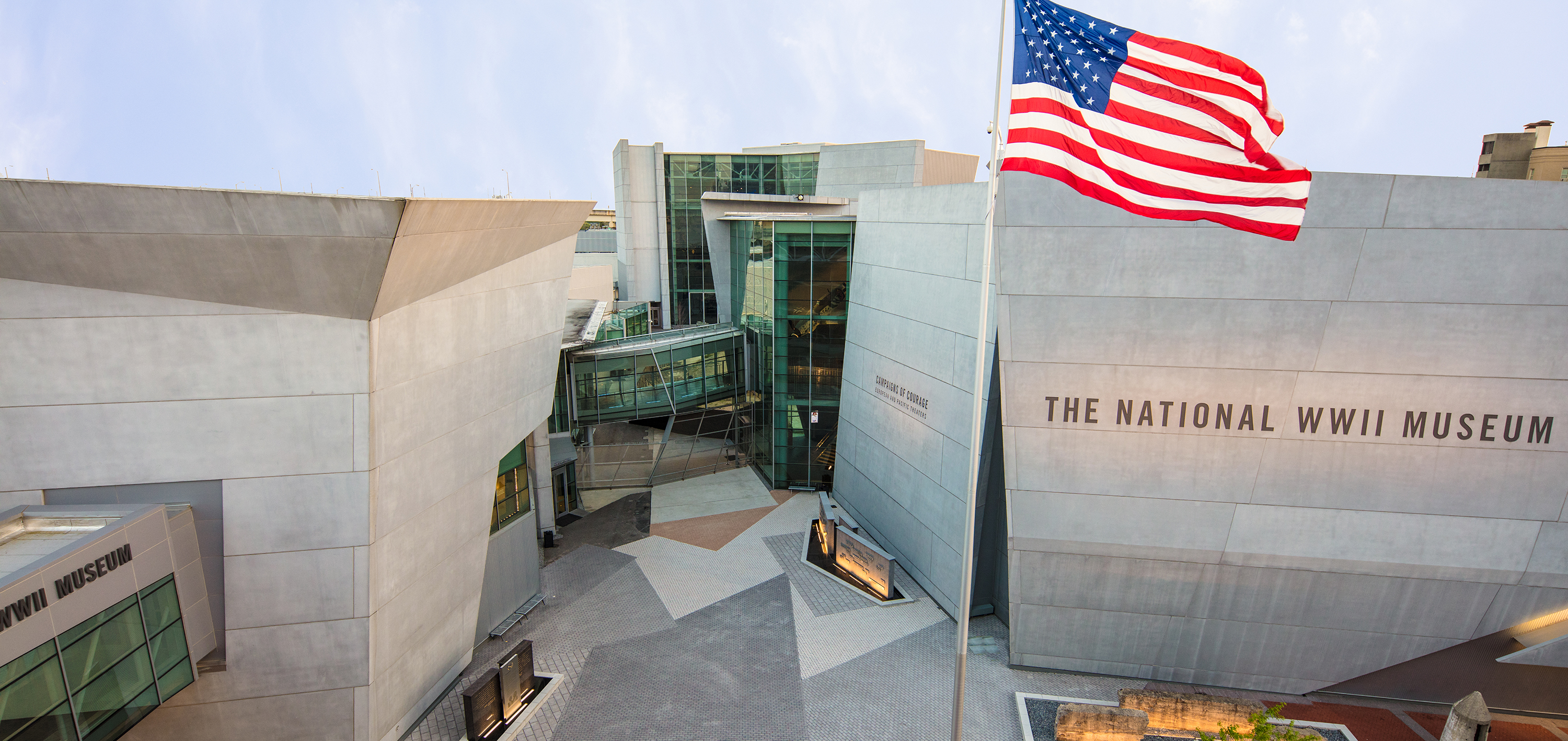 Roof-height view of the exterior of the National WWII Museum with American flag featured