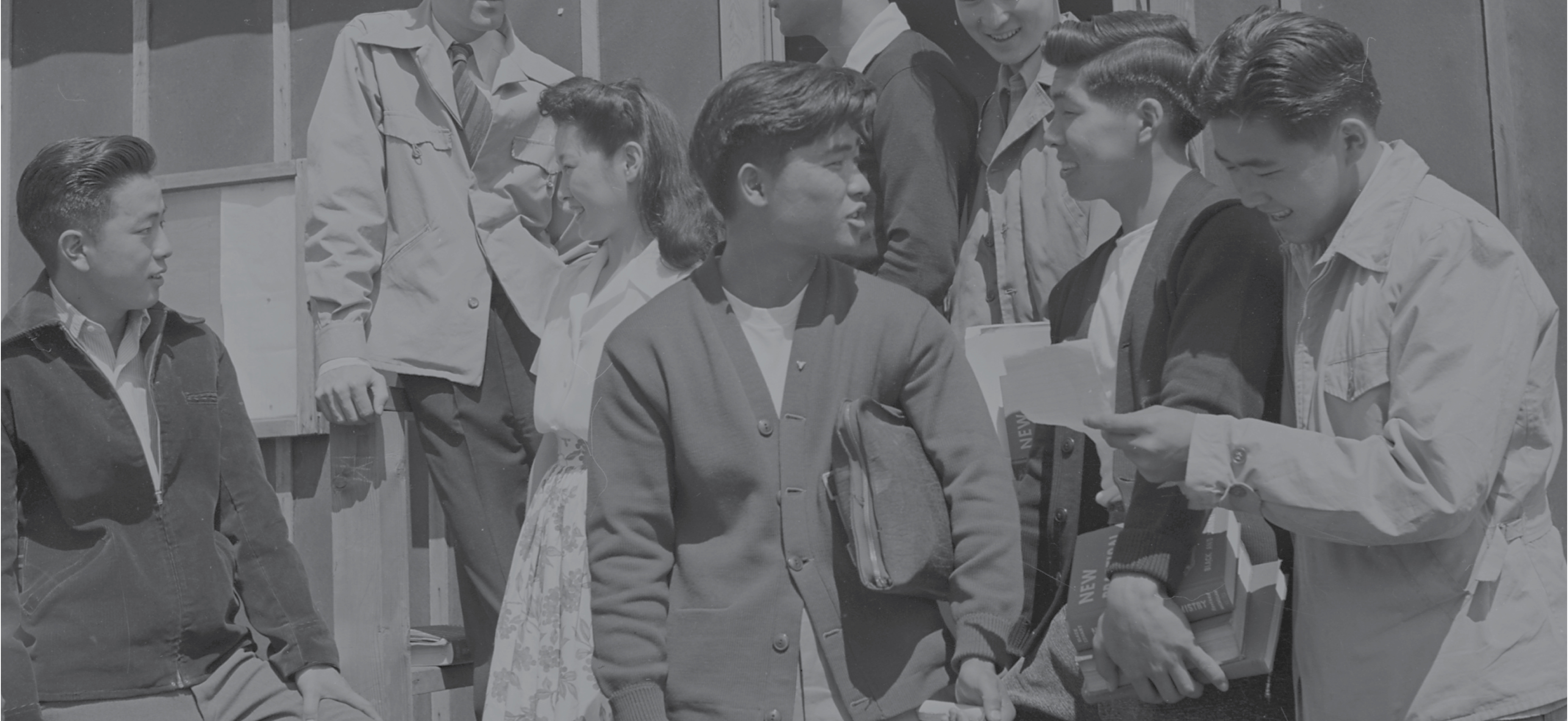 Group of Japanese Americans mingle in historic photo from the 1940s.