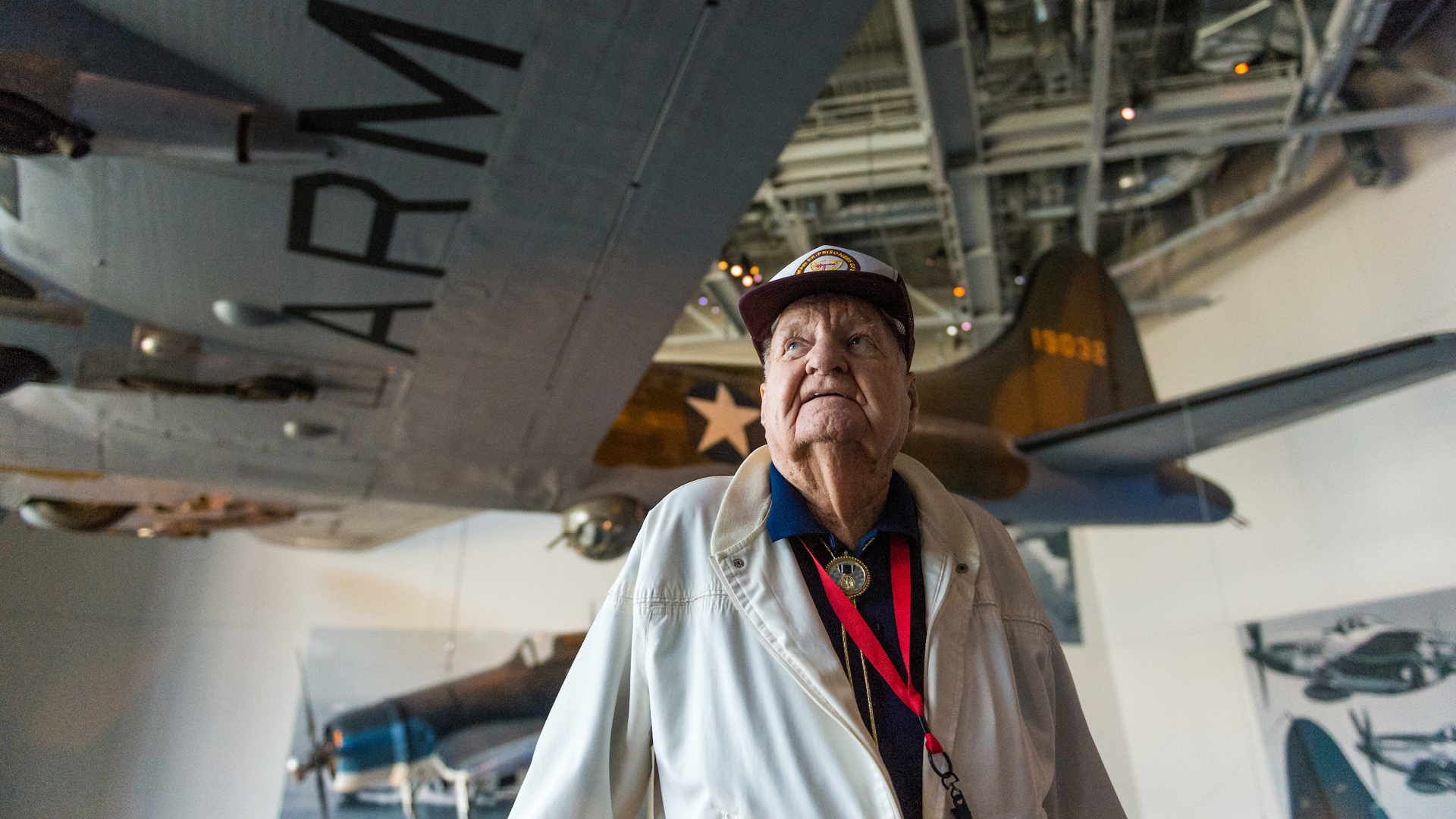 WWII Veteran in front of hanging airplane at the National WWII Museum in New Orleans