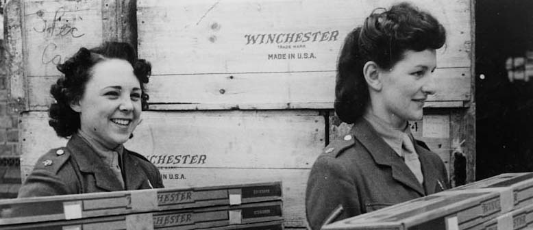 2 female soldiers carrying boxes of Winchester rifles