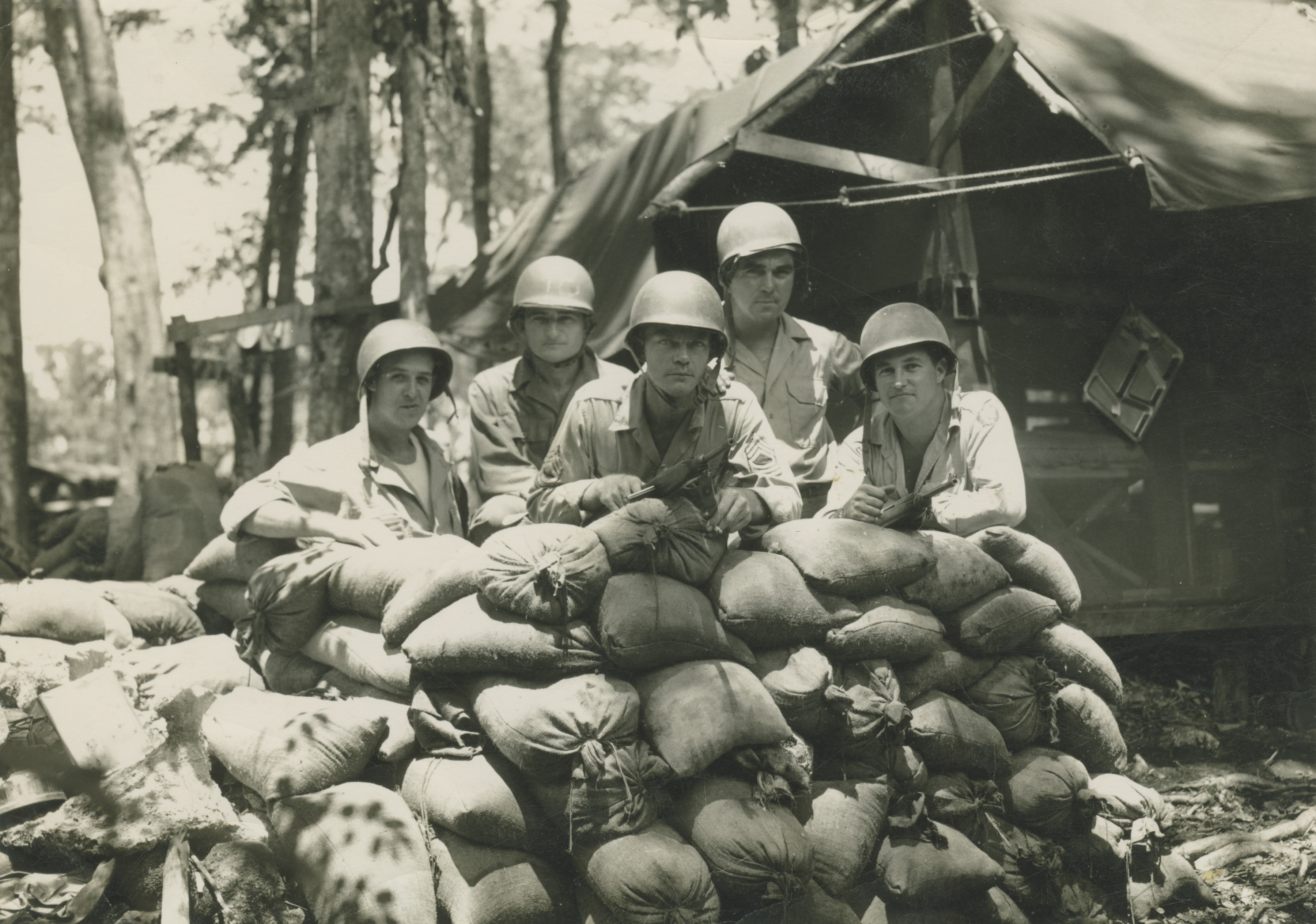 Soldiers pose behind sandbags during WWII