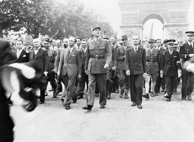 General Charles de Gaulle and his entourage proudly stroll down the Champs-Élysées to Notre Dame Cathedral for a Te Deum ceremony following the city&#039;s liberation on August 25, 1944. 