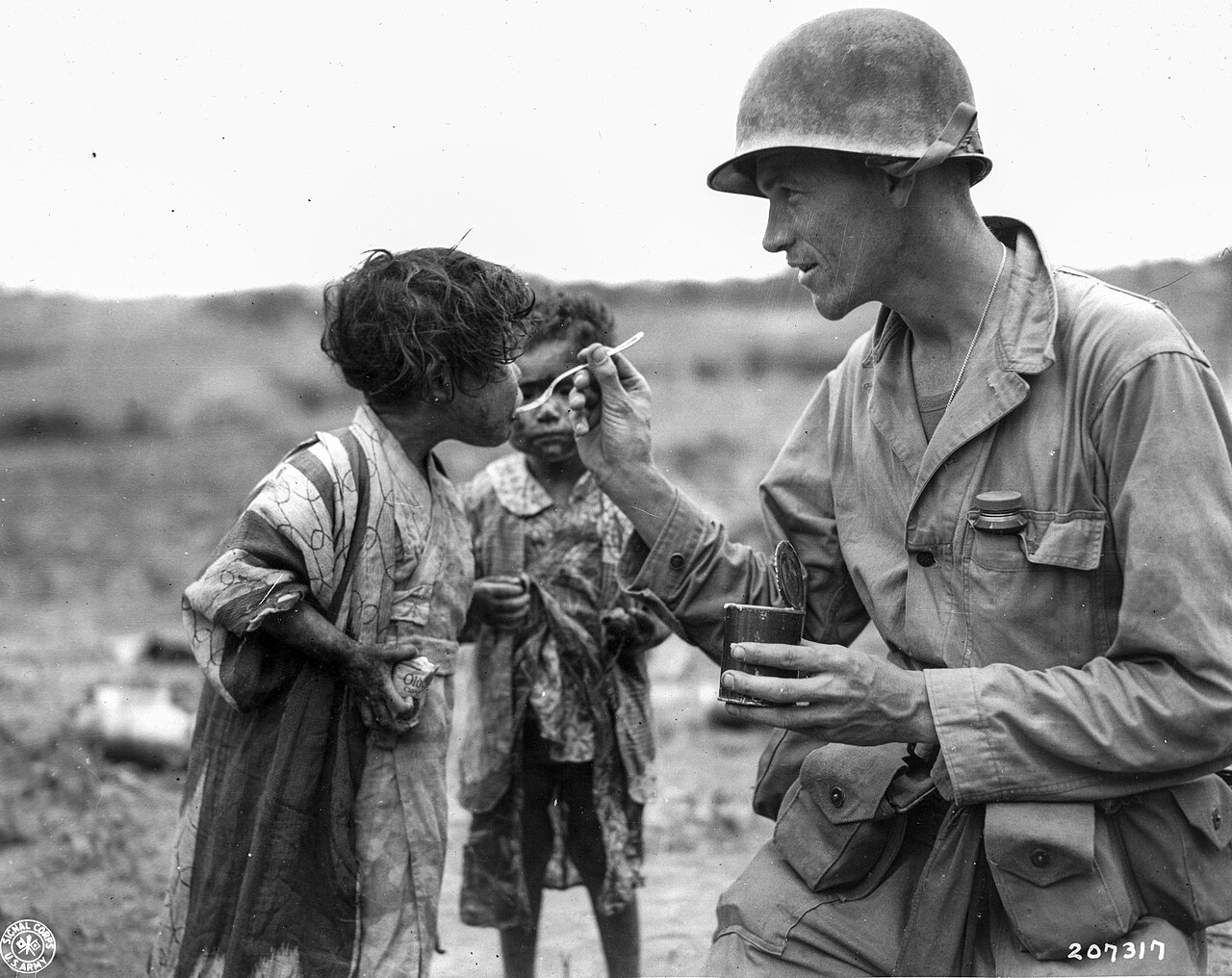 Lt. Richard K. Jones feeds children found in a tomb