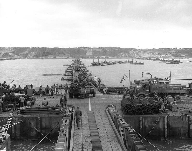 U.S. Army vehicles proceeding ashore on a floating causeway of Mulberry A