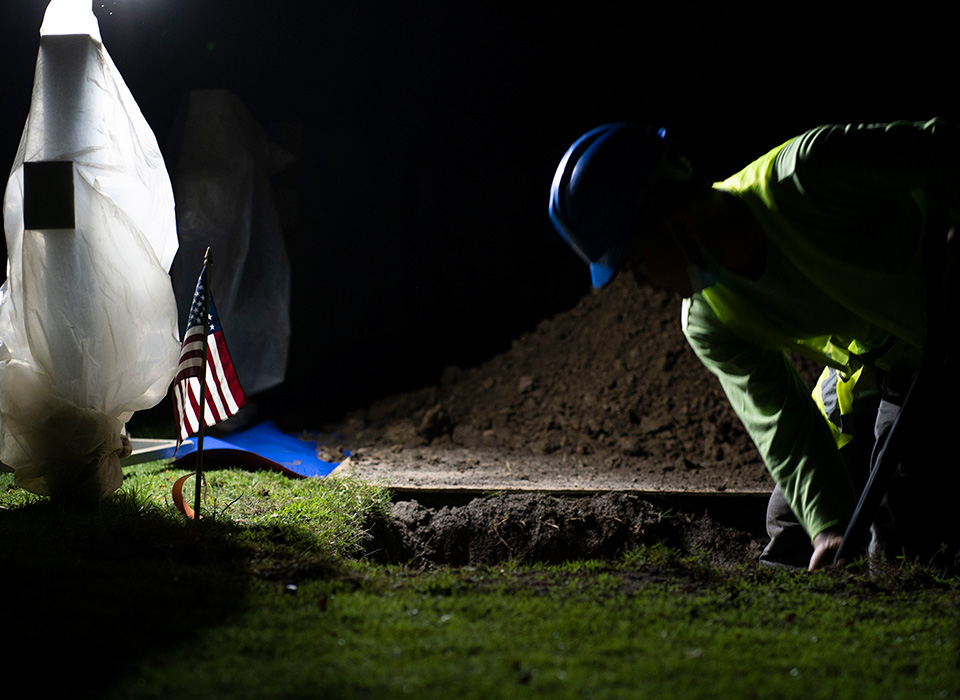 Staff with the American Battle Monuments Commission (ABMC), work in conjunction with members of the Defense POW/MIA Accounting Agency (DPAA), to exhume a casket during a disinterment