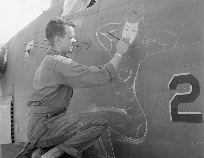 Sgt. J.S. Wilson, USA, painting a design of prow of a bomber