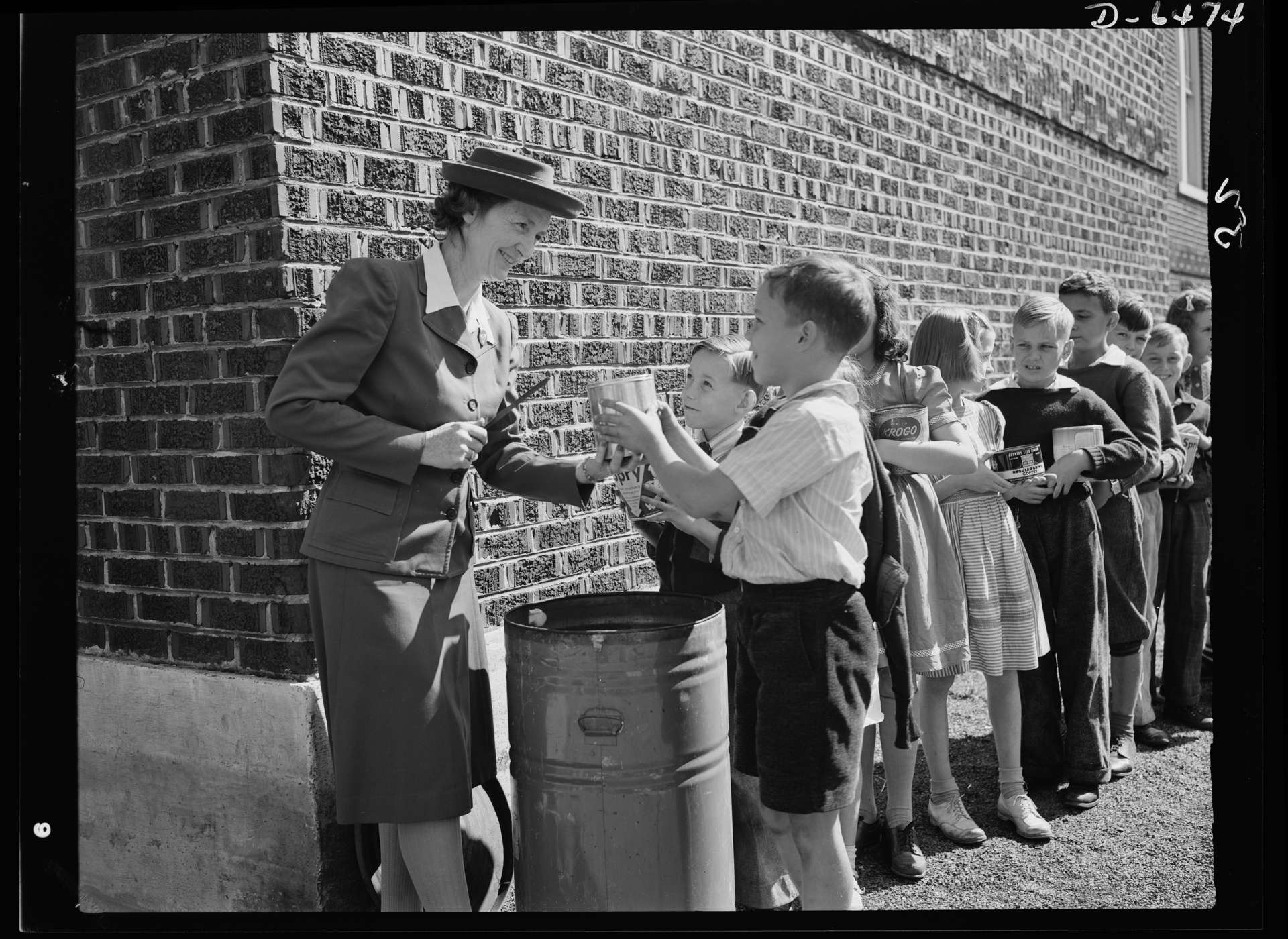 Schoolchildren deposit waste cooking fats collected from their neighbors (1942).