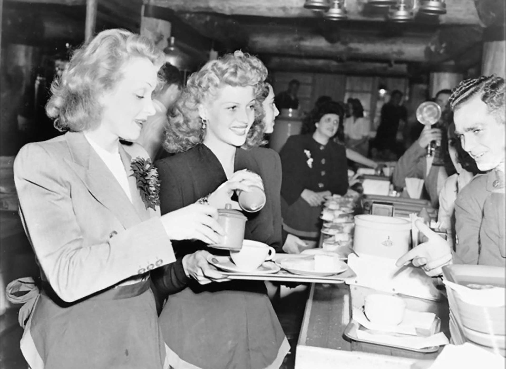 Actresses Marlene Dietrich and Rita Hayworth serve food to soldiers at the Hollywood Canteen in Hollywood, California.