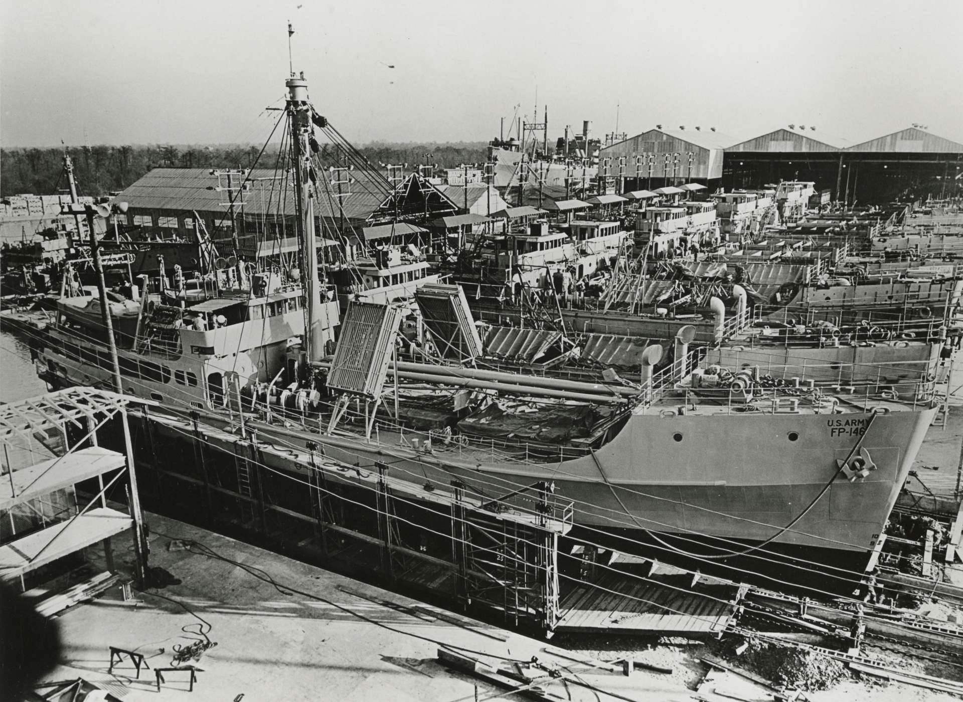 One hundred FP, later designated FS (Freight, Supply) ships, were built at Industrial Canal on a moving assembly line. As each ship reached the end of the line it was launched, stern first, into the Industrial Canal for final testing. In this image, FP-146 is nearing completion and launch.
