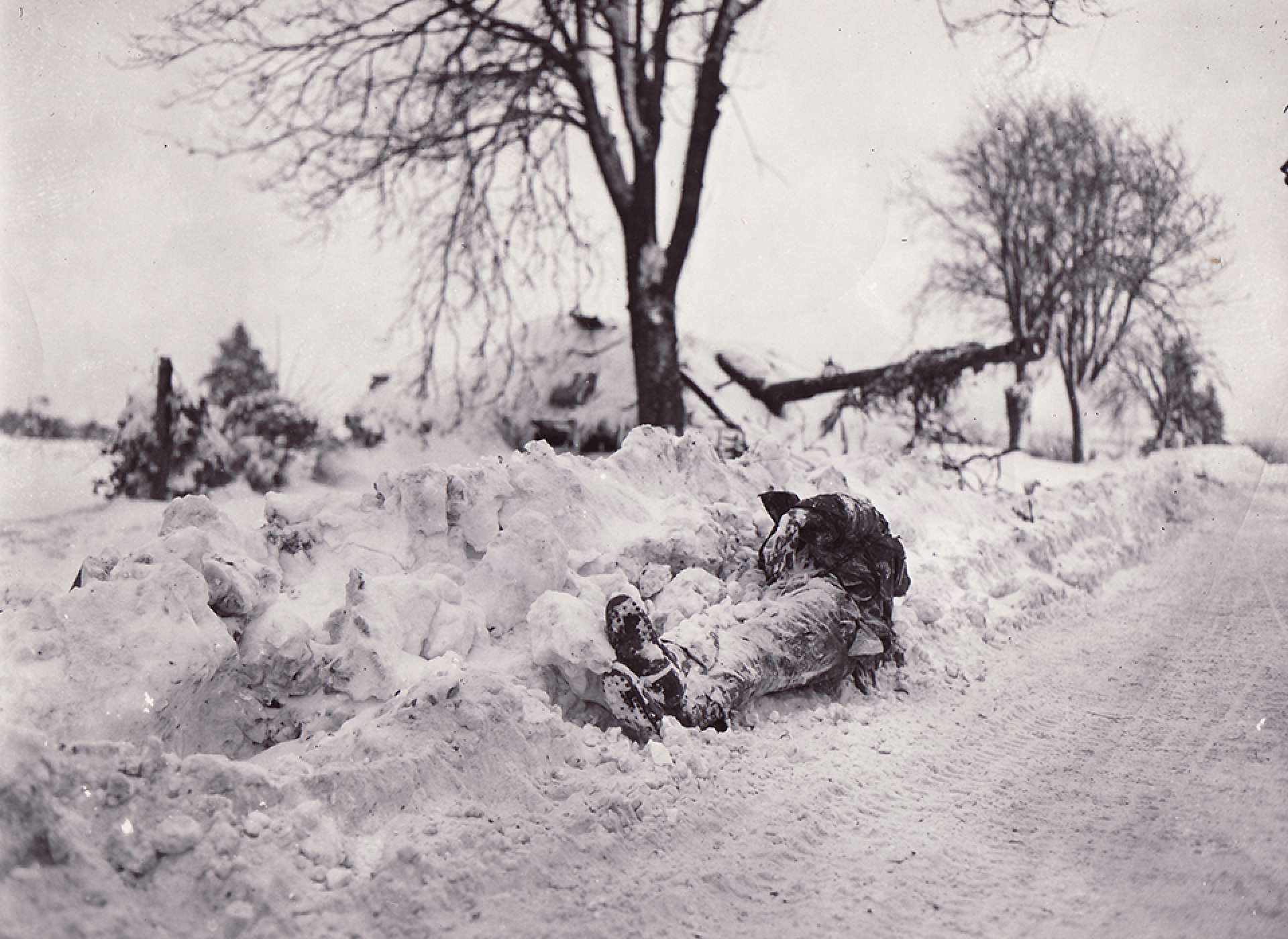 Dead German tanker with destroyed tank in background near Bullingen, Belgium - taken with 9th Inf. Regt, 2nd Division. The National WWII Museum Digital Collections.