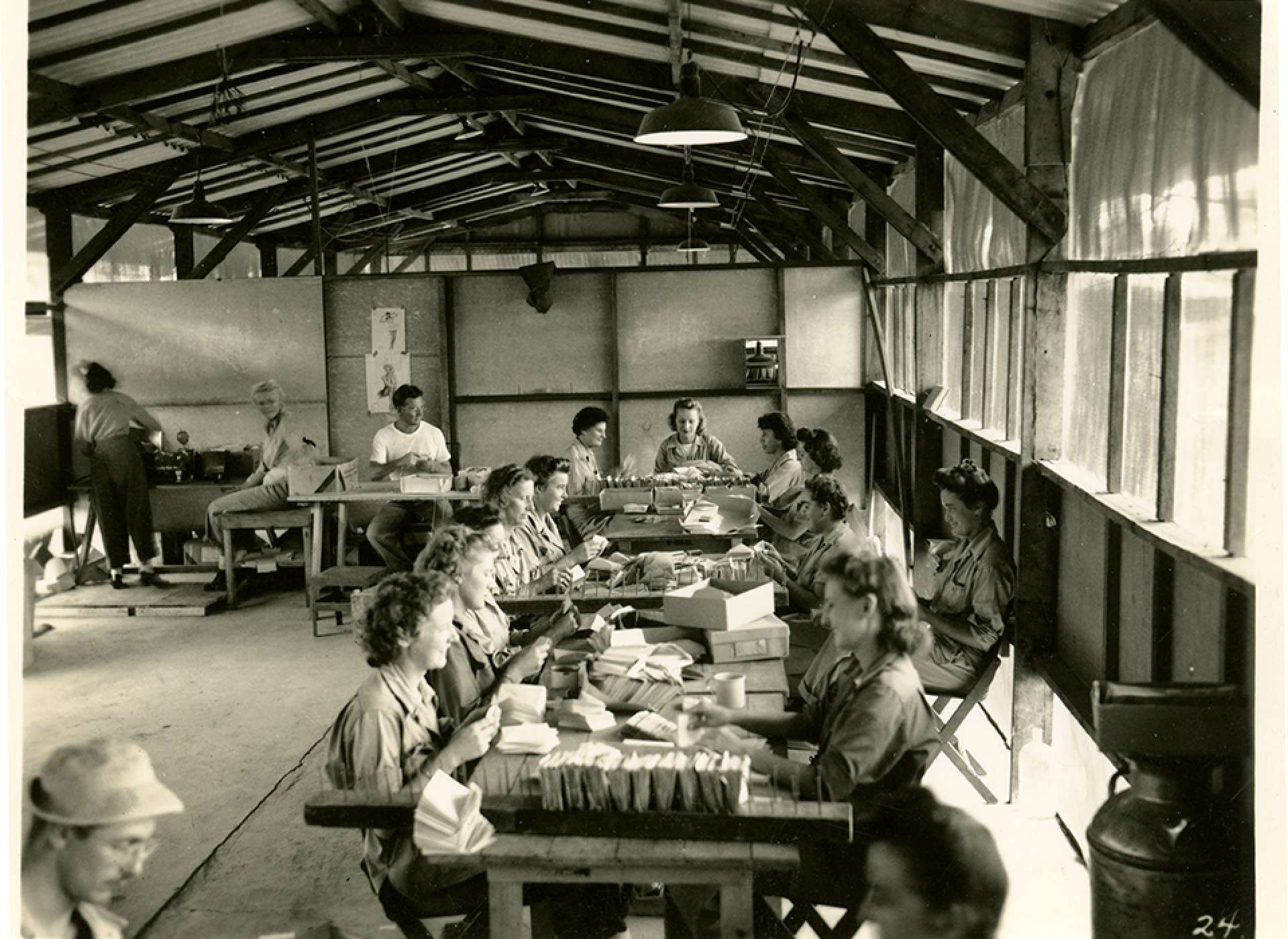 V-mail operation in the field at APO 929.&quot;This is a view of the inserting and sealing. At the long table the girls must hand-insert each letter, after which all the envelopes are fed through a sealing machine. In the rear, the sealed letters are then bundled and bagged for dispatch to the Post Office.&quot;