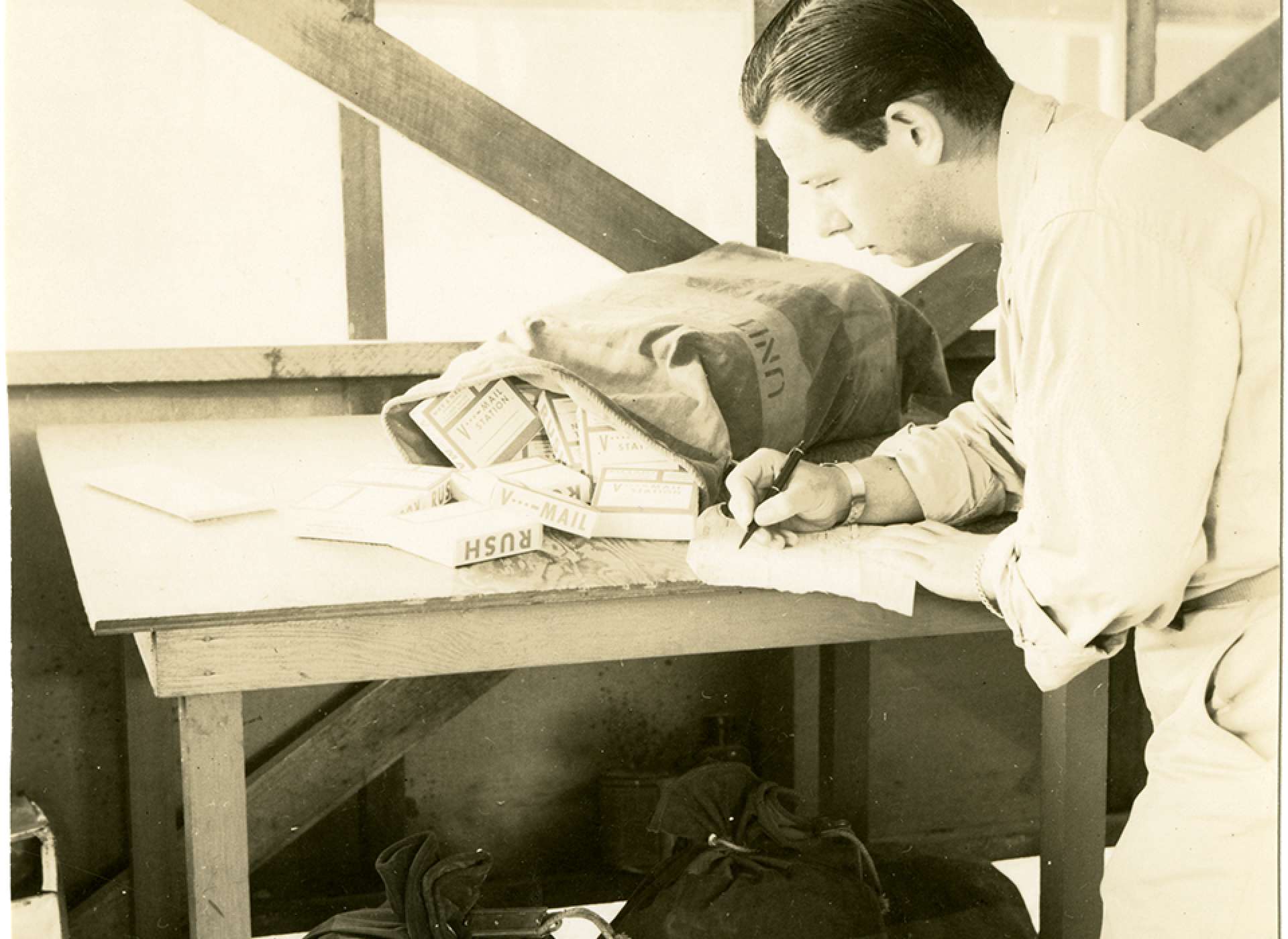 V-mail operation in the field at APO 929. “Initial step in the Receiving section is this operation of checking the postal dispatch sheets and logging in the rolls received from the States. This section is now receiving and completely processing an average of seventy rolls per day.” Port Moresby, Papua New Guinea. 1944