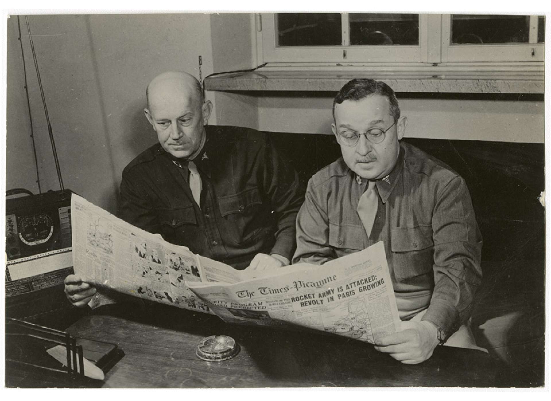 Home was never too far away. Colonel Royals and Major George Grant (L-R), the Commanding and Executive Officers of the 24th General Hospital, read copies of the New Orleans newspaper Times-Picayune in Florence. The National WWII Museum.