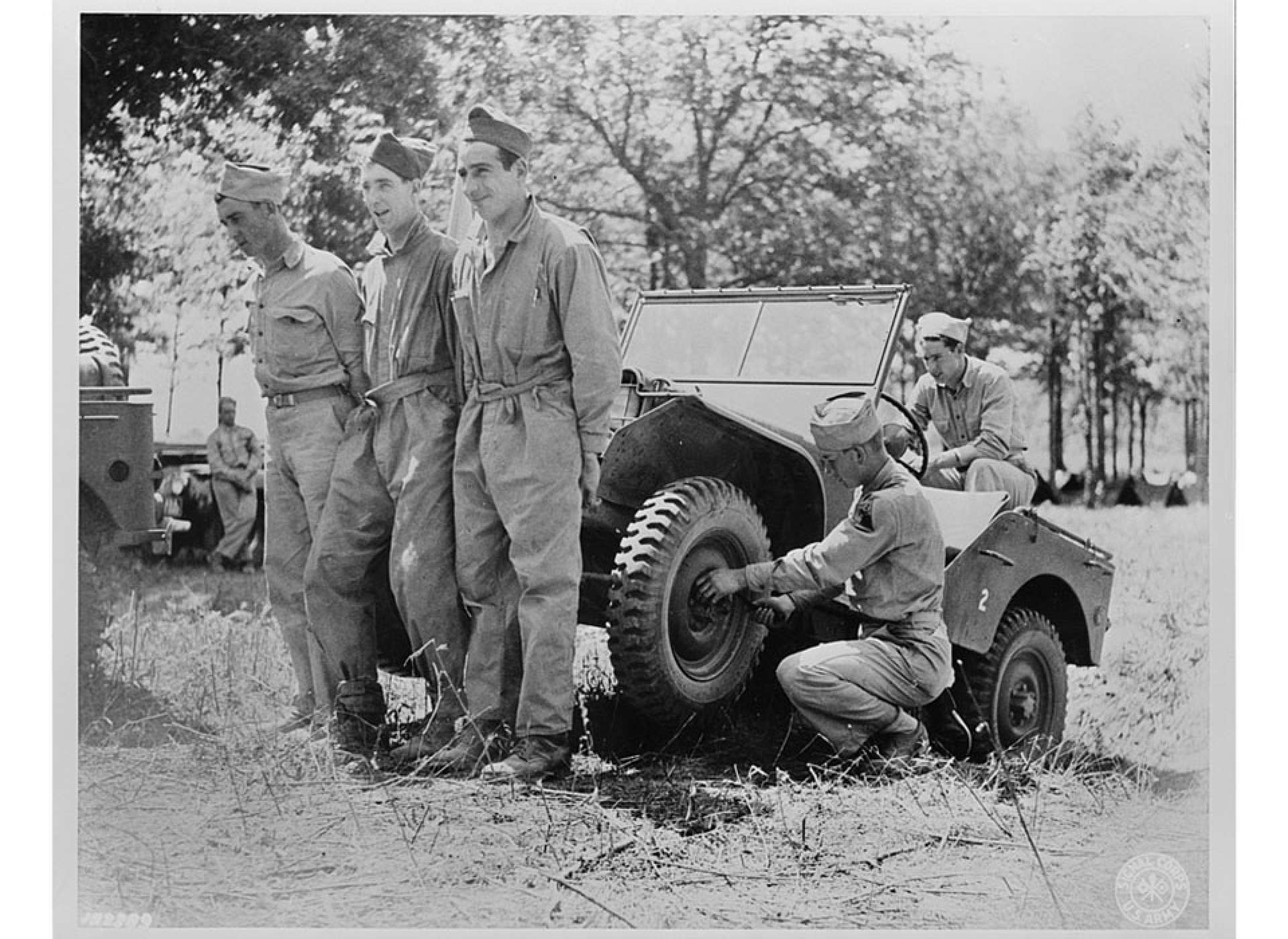 Soldiers of headquarters company of the Armored Corps lifting a jeep to repair it at their bivouac area during Second Army maneuvers, June 1941. Library of Congress
