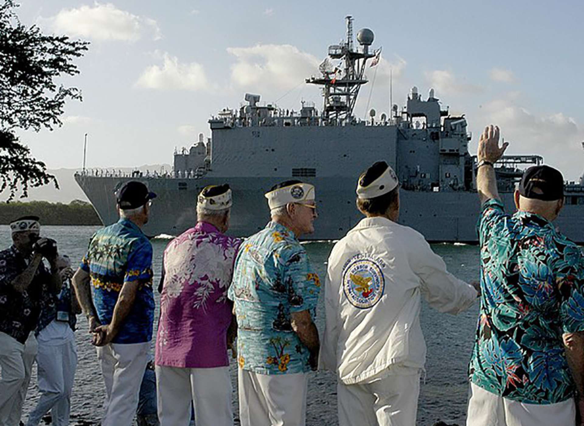 Survivors and guests wave to the USS Pearl Harbor during a joint US Navy/National Park Service ceremony commemorating the 65th Anniversary of the attack on Pearl Harbor