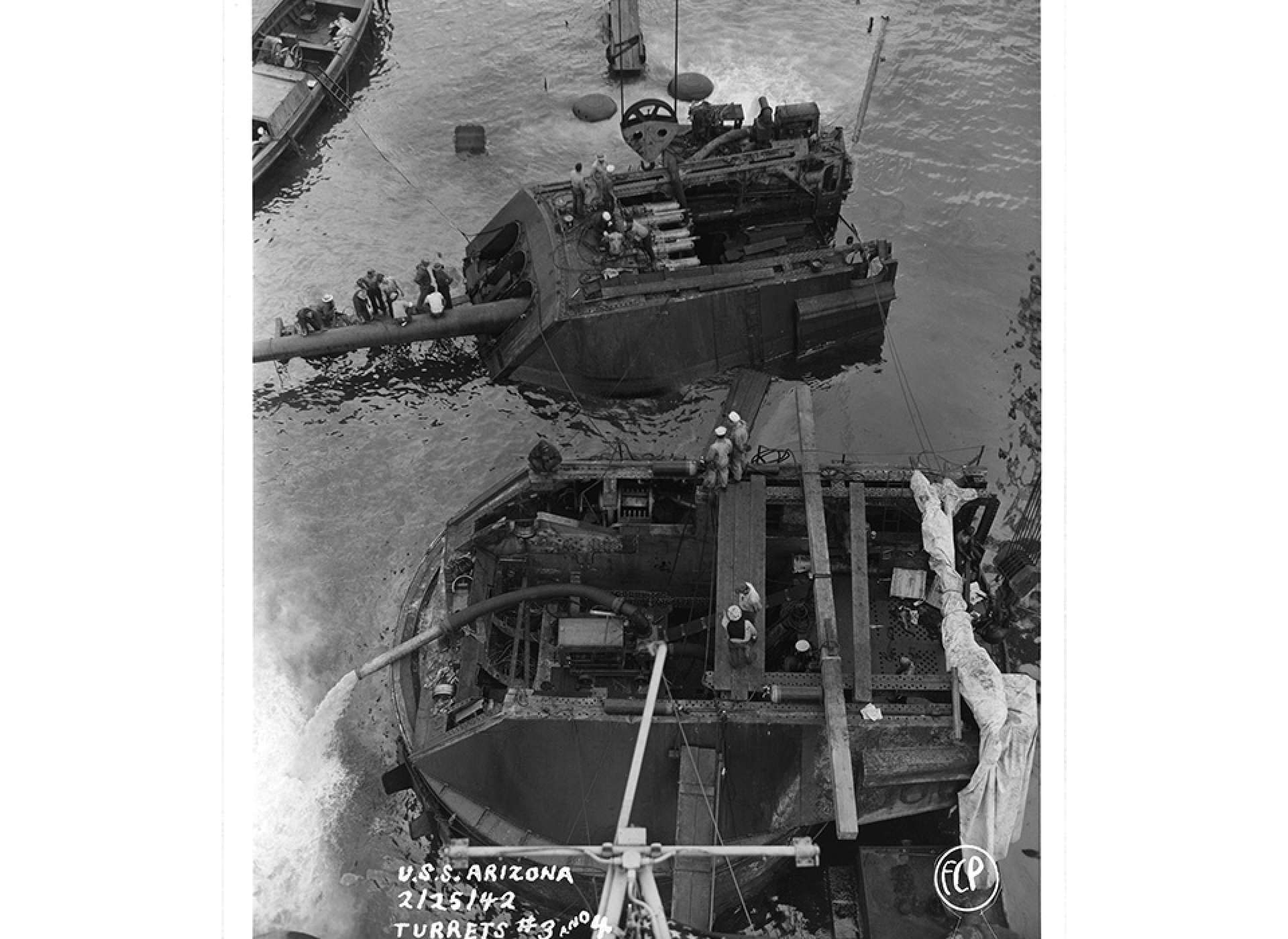 In February of 1942, crews work to extract the USS Arizona’s aft turrets during salvage operations