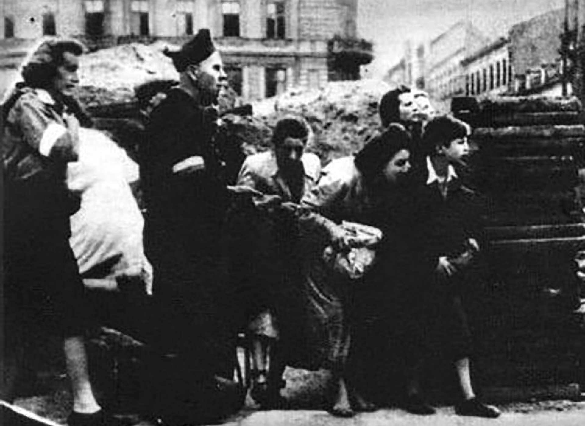 Civilian hide behind make-shift barriers at a street crossing Warsaw Uprising 