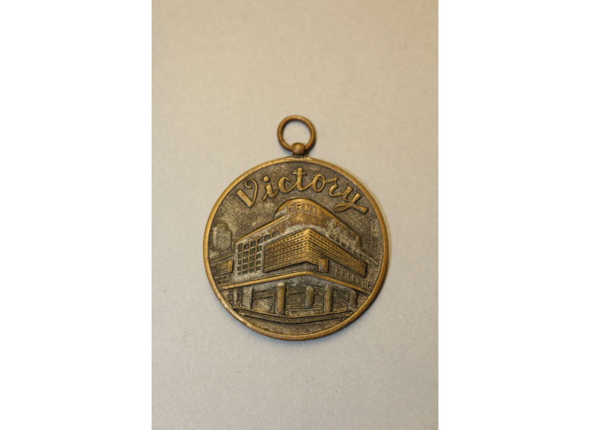 The obverse of a 1947 postwar souvenir medal featuring the Ernie Pyle theater. The National WWII Museum, Gift in memory of Fr. John Francis McMahon, 2008.457.021.