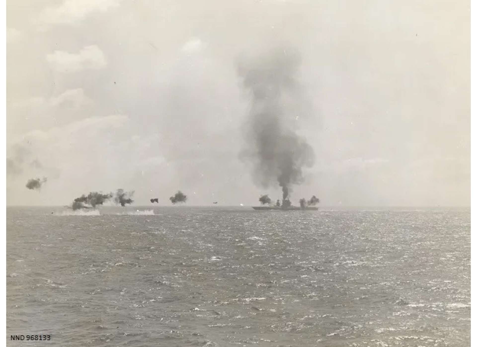 The USS Lexington after the initial torpedo hits. A Japanese torpedo plane is approaching from the left. Official US Navy photograph courtesy of the National Archives and Records Administration.
