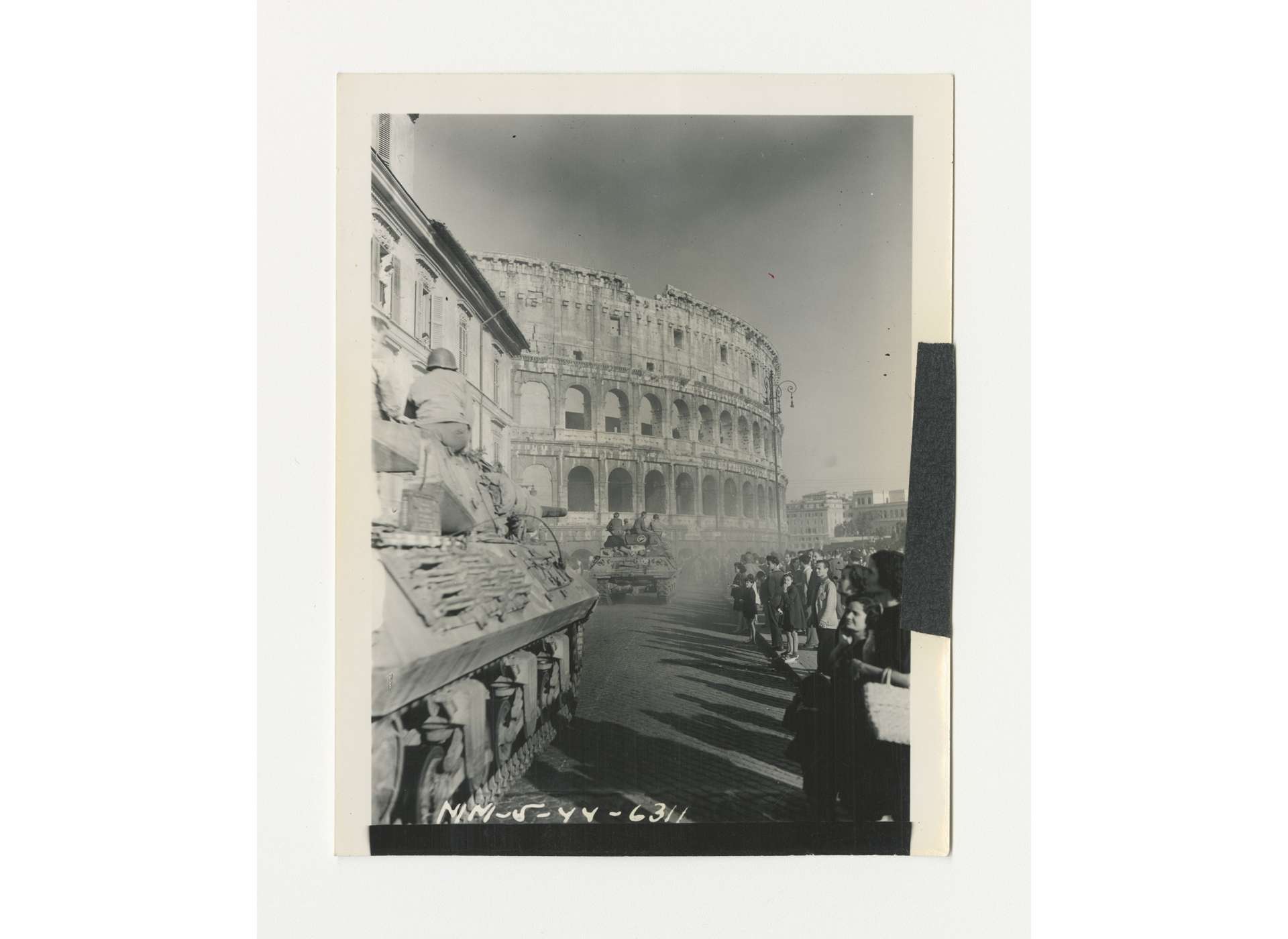 Men and tanks of the US 1st Armored Division, Fifth Army, stream by the Colosseum in Rome, June 5, 1944. US Army Signal Corps photo, gift of Ms. Regan Forrester, from the Collection of The National WWII Museum, 2002.337.624.