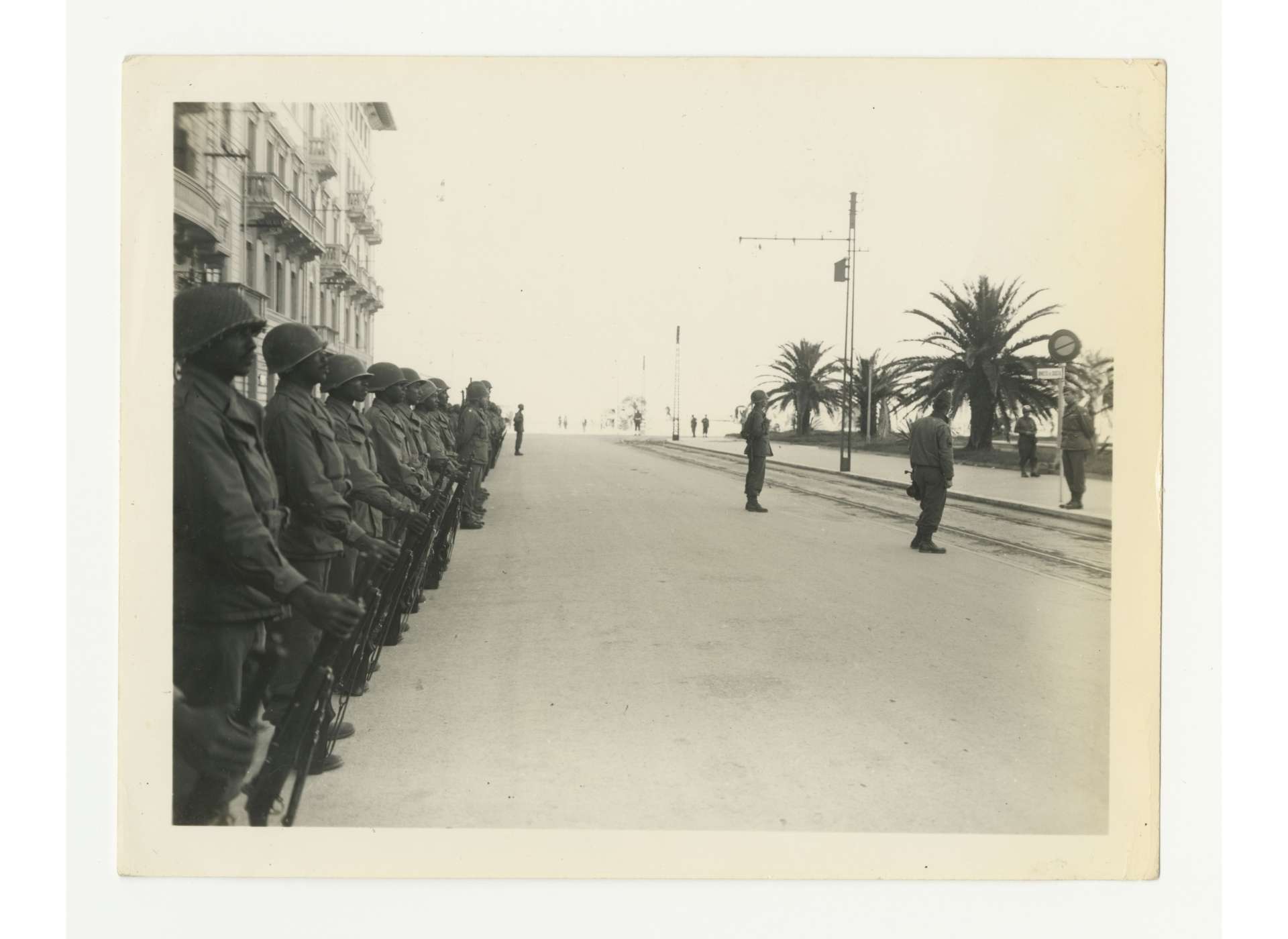African-American soldiers of the 92nd Infantry Division, 370th Regimental Combat Team stand at attention while Lt. General Mark Clark speaks to them during a decoration ceremony, Via Reggio area, October 20, 1944. US Army Signal Corps photo, gift in memory of William F. Caddell, Sr., from the Collection of The National WWII Museum, 2007.048.337.