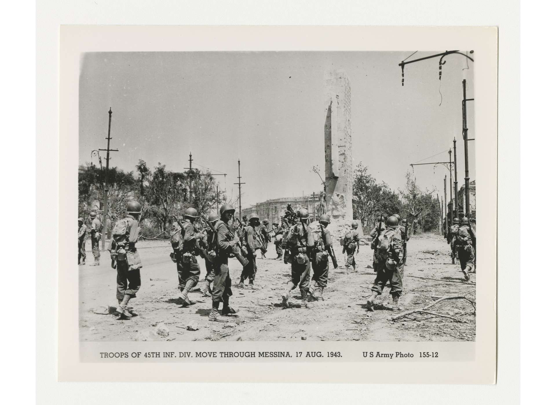Members of the US 45th Infantry Division walking through wartorn Messina, August 17, 1943. Gift in memory of Sgt. Lyle E. Ebersprecher, from the Collection of The National WWII Museum, 2013.495.970.
