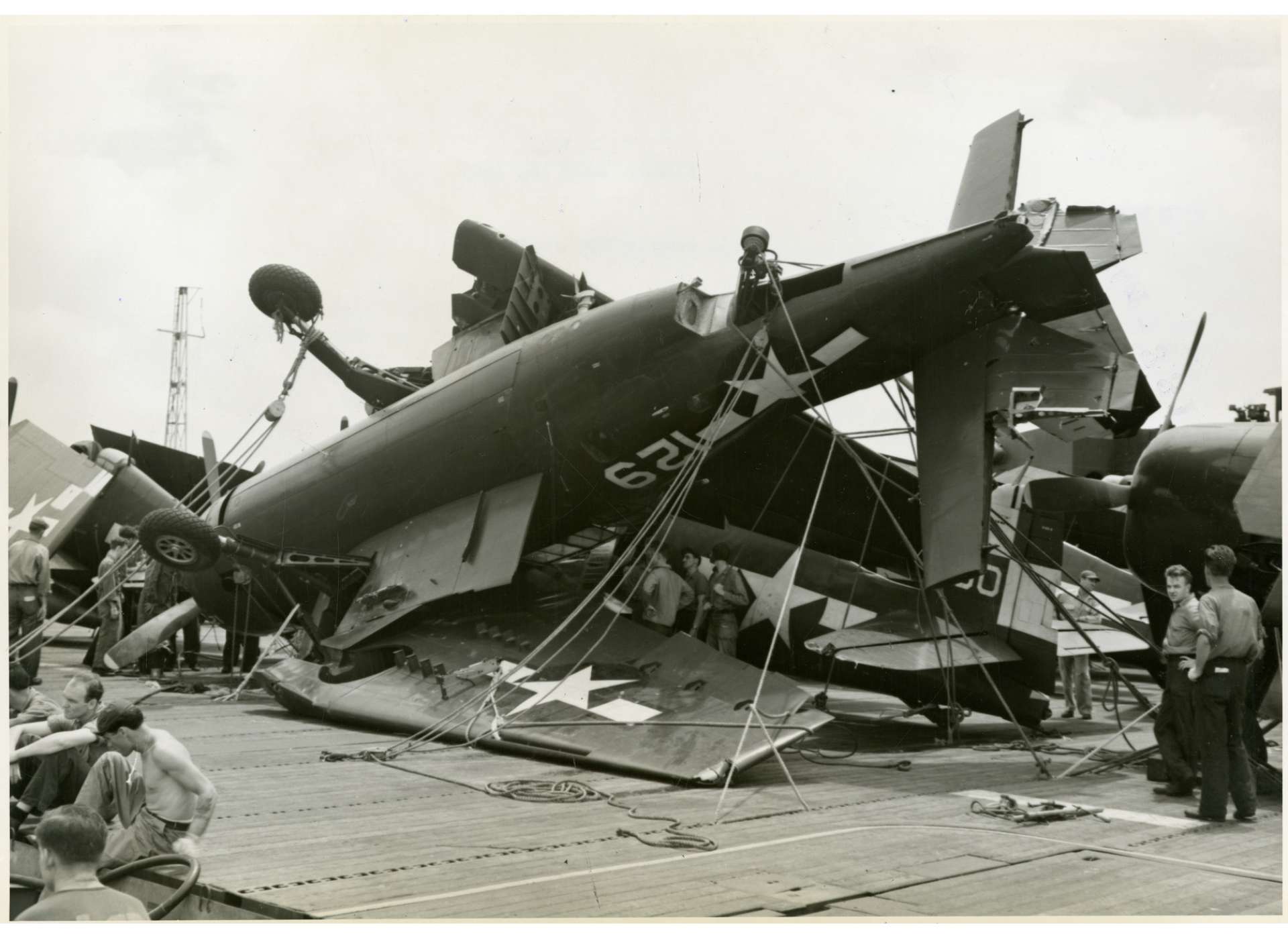 Crews inspect the mangled remains of a TBM Avenger on the deck of the USS Hornet [ITALICS] (CV-12) after Hurricane Cobra swept through in 1944. The National WWII Museum, Gift of Nap Pozulp, Ph.D., 2018.067.798.