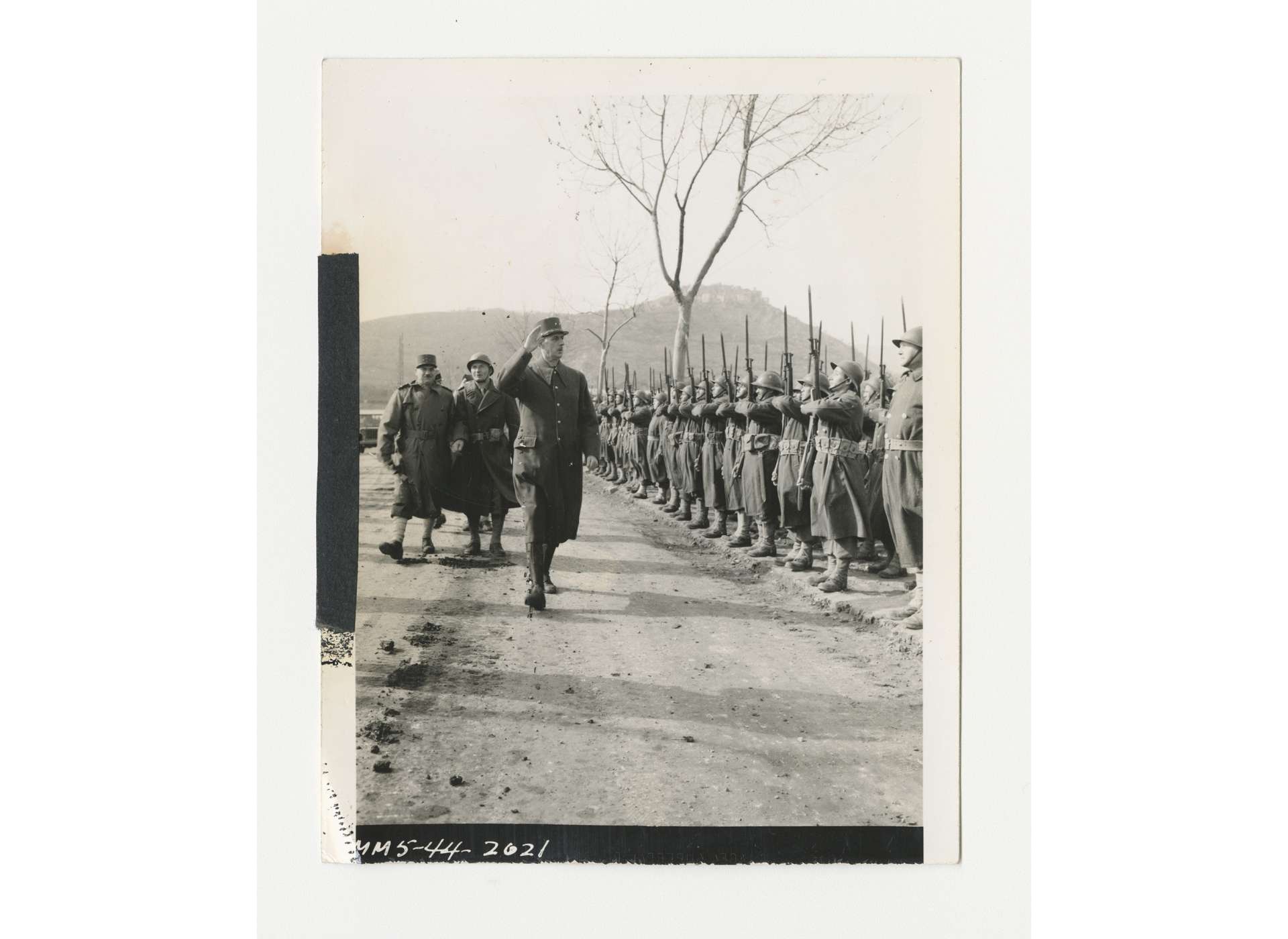 General Charles de Gaulle, Chairman of the French National Committee of Liberation, salutes the Honor Guard while reviewing Free French troops near Venafro, Italy, March 9, 1944. US Army Signal Corps photo, Gift of Ms. Regan Forrester, from the Collection of The National World War II Museum, 2002.337.142.