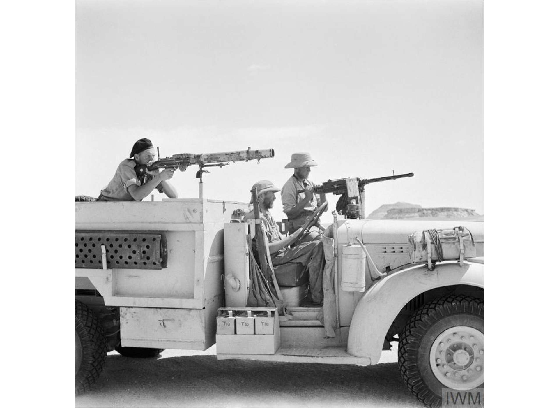 An LRDG Chevrolet truck and its three man crew. The gunner beside the driver is manning a Browning Mk II aircraft machine gun, while the gunner in the back has a Lewis gun. May 1942
