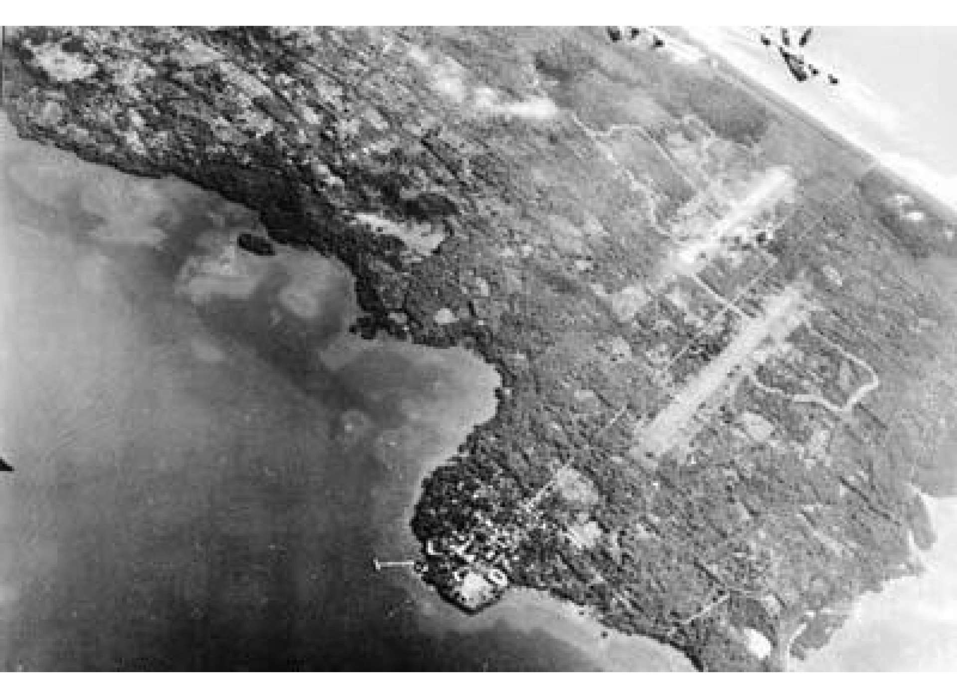 An aerial view of American B-24s over Puerto Princesa Airfield, Palawan. The airfields at Puerto Princesa were constructed by the American POWs from Camp 10-A nearby, who in the fall of 1944 also were forced to make repairs on an almost daily basis. USAAF photo