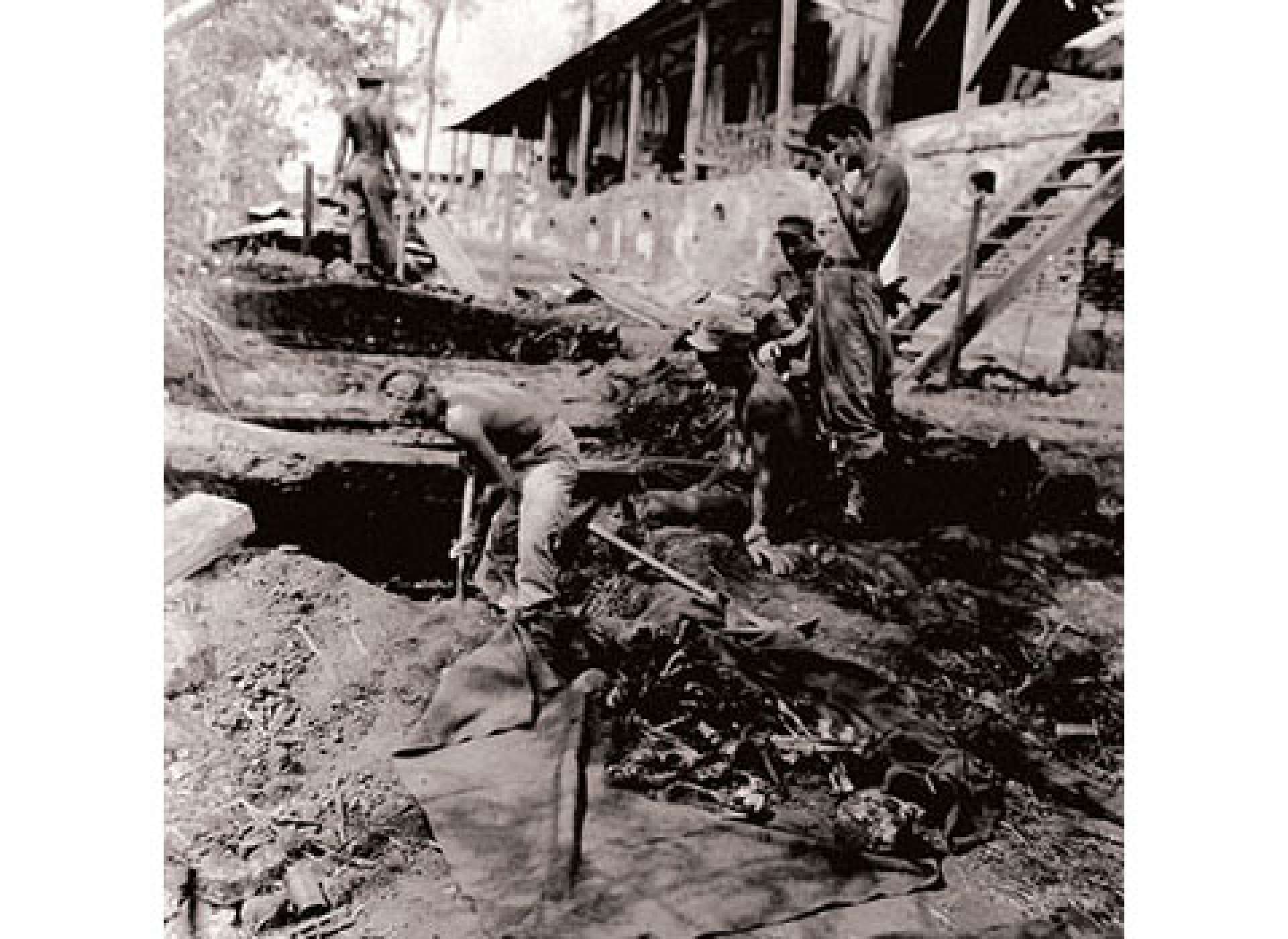 In March 1945, American military personnel worked to excavate the bodies from the first air raid shelter in which the American POWs were executed at Camp 10-A. Courtesy of the US Army.
