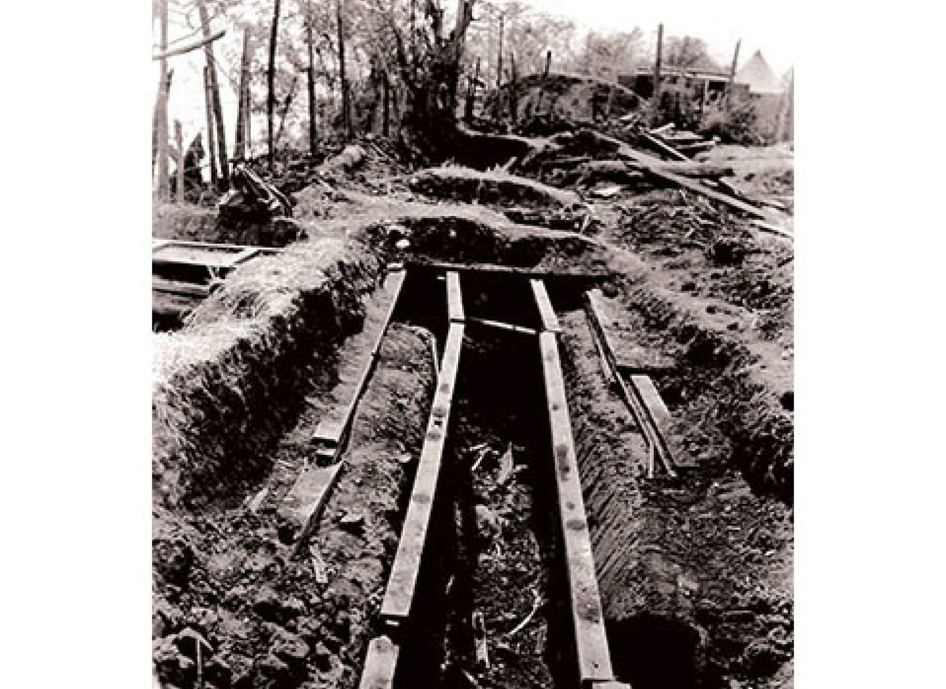 The recovery efforts in the second large shelter at Camp 10-A revealed the bodies of American POWs burned to death in the trench. Courtesy of the US Army.