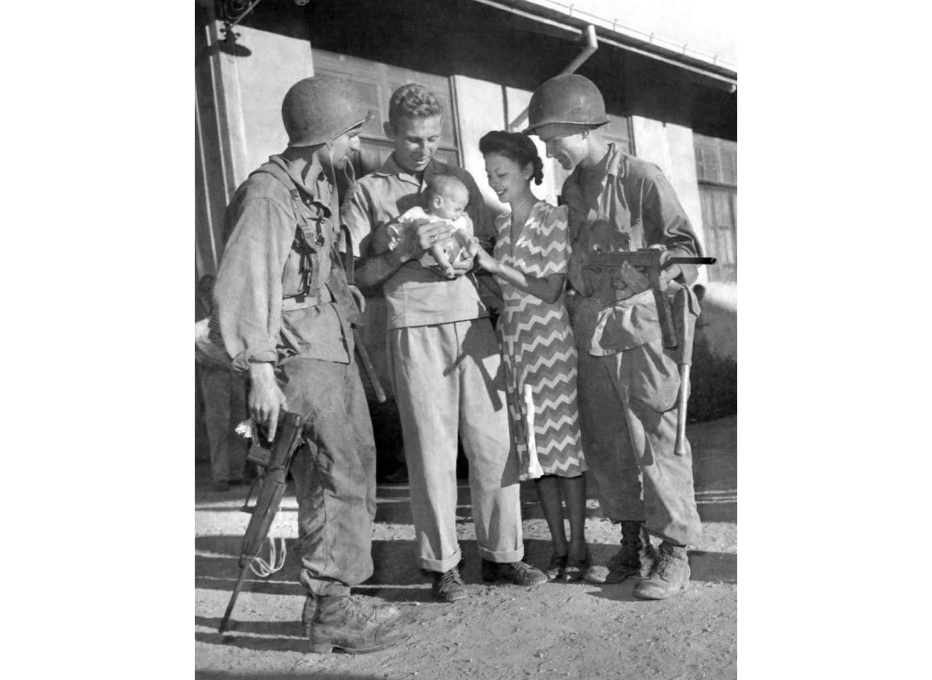 Los Baños internees, Hal Bowie and his wife and baby daughter, with 11th Airborne paratroopers shortly after the raid, 23 February 1945. US Army Signal Corps Photo courtesy of the National Archives.