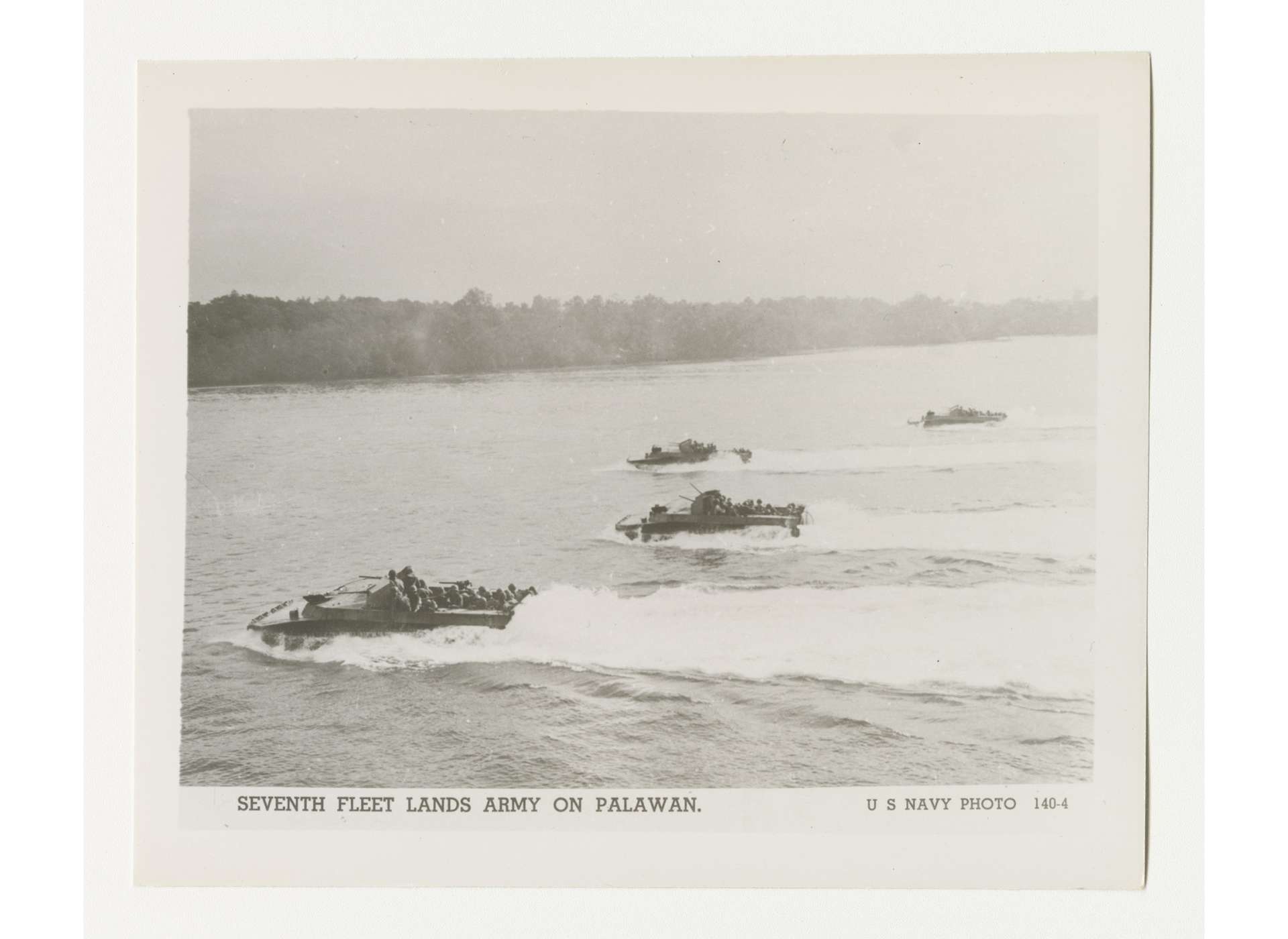 On February 28, 1945, the US 41st Infantry Division conducted an assault landing at Palawan in US Navy LVTs (Landing Vehicles, Tracked). On the same date, the Palawan Special Battalion, instrumental in the safeguarding the POWs who survived the massacre on Palawan, came under the operational control of the division. US Navy Photo 140-4, Gift of Lyle E. Eberspecher, from the Collection of The National World War II Museum, 2013.495.902.