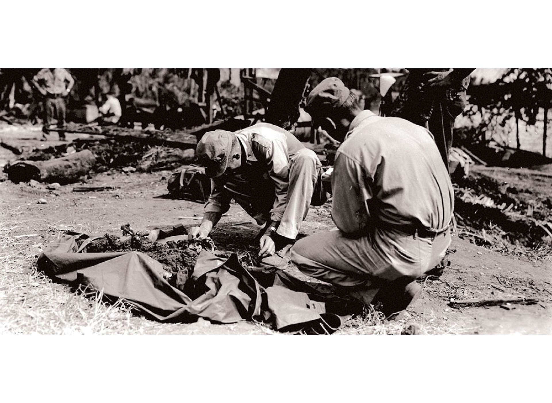 During recovery operations at Camp 10-A in March 1945, officers and medical personnel looked for anything to help them identify the victims of the Palawan massacre. In 1952, the remains of 123 of the victims were reinterred in a mass grave in the Jefferson Barracks National Cemetery near St. Louis. Photo courtesy of the US Army.