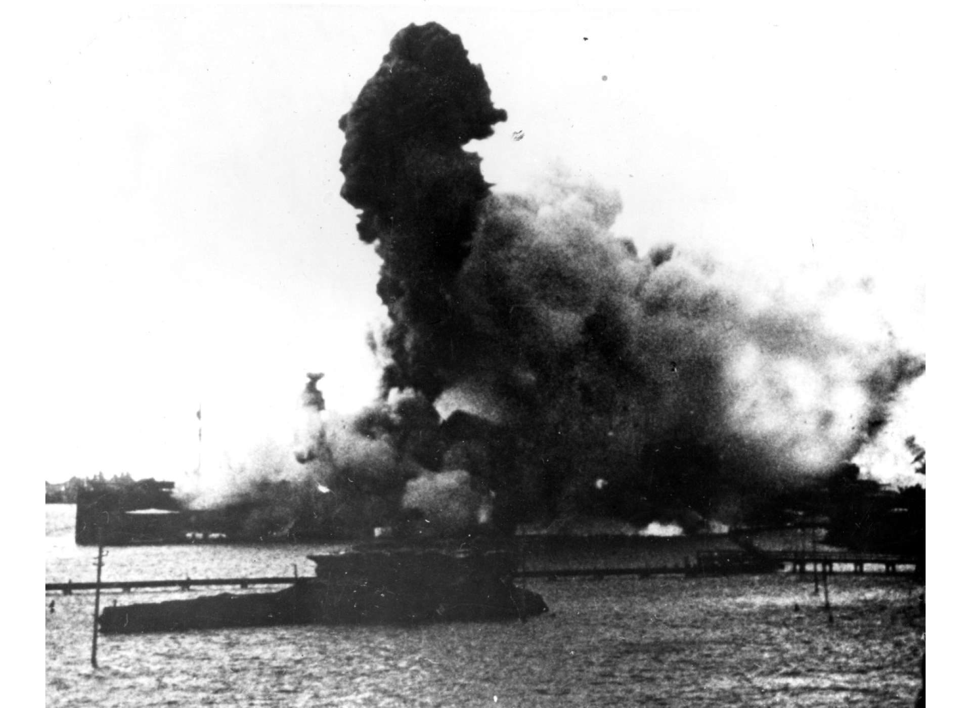 Forward magazines explode on USS Arizona, after it was hit by a Japanese armor-piercing bomb. Official US Navy Photograph, now in the collections of the National Archives.
