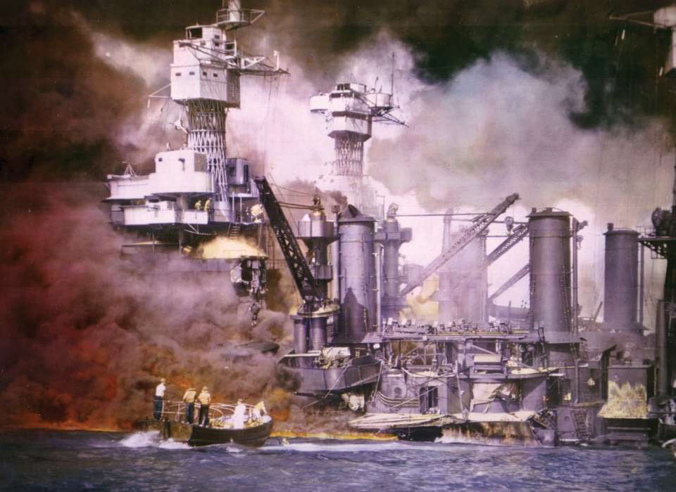 Smoke rising from burning ship while boats attempt to put out fires during Pearl Harbor