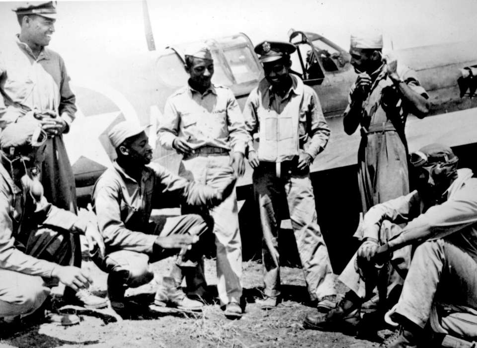 Pilots of the 99th Fighter Squadron discuss dogfights over the beaches south of Rome, Italy, after another successful mission in January 1944.