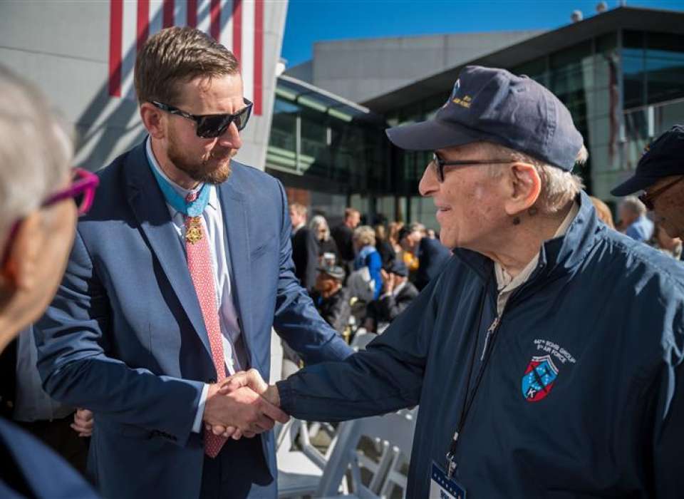 Medal of Honor Recipient Ryan Pitts shakes hands with WWII veteran Norman Bussel 
