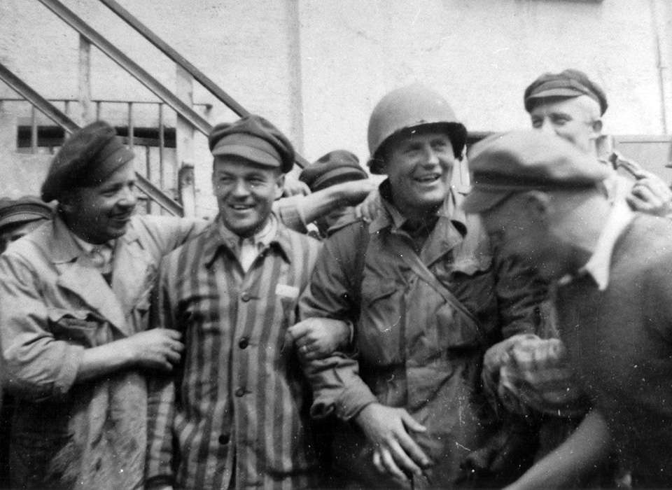 An American Soldier is surrounded by survivors at the newly liberated Dachau concentration camp