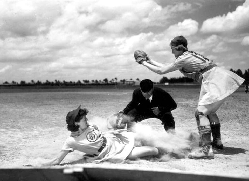 Vivian Kellogg, catcher with the Fort Wayne Daisies (AAGPBL) awaits a throw as second baseman Marg Callaggah slides safely into home