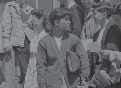 Group of Japanese Americans mingle in historic photo from the 1940s.
