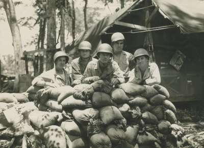 Soldiers pose behind sandbags during WWII